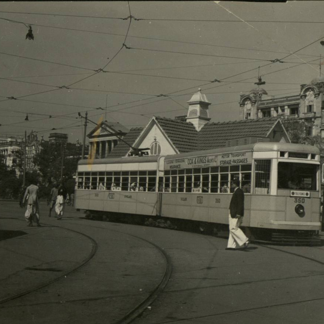 A person walking on a street with public transport.